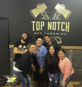 Group posing with axe master at top notch axe throwing